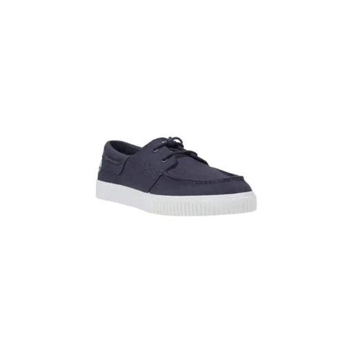 Navy blue boat shoe with white sole displayed in product listing