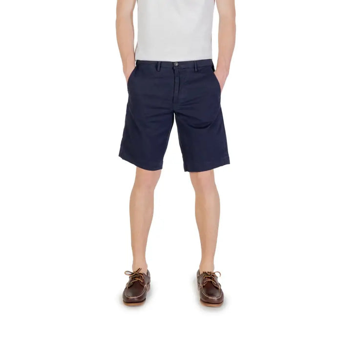 Navy blue chino shorts displayed in a men’s ensemble with white chinos and brown boat shoes