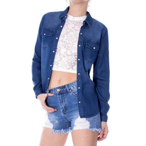 Navy blue denim button-up shirt over white lace crop top and distressed shorts