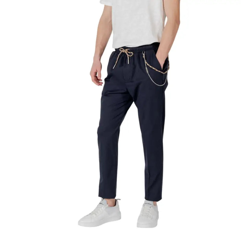 Navy blue tapered trousers with a drawstring waist and decorative chain detailing on the side in dark navy fabric
