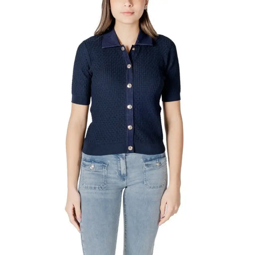 Navy blue knit button-down shirt paired with light blue jeans in a fashion display
