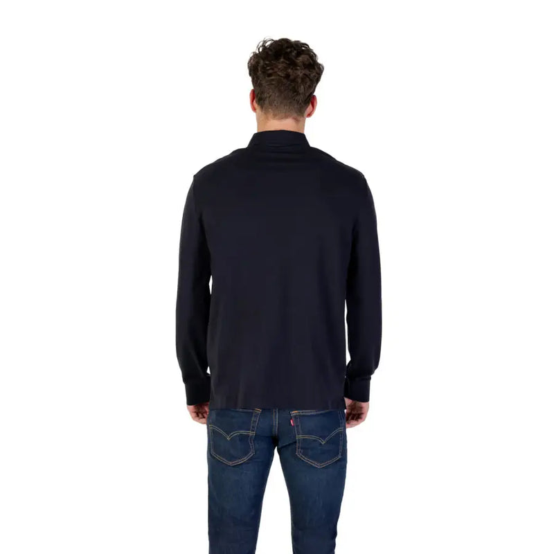Chemise noire à manches longues et col en coton, portée par un homme et convenant aussi bien aux tenues décontractées qu'aux tenues habillées.