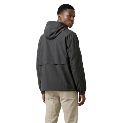 New Balance Blazer homme noir en nylon à capuche et fermeture éclair, design élégant gris foncé et détails de coutures discrets.