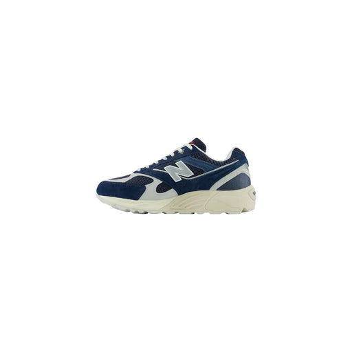 New Balance Baskets homme en cuir suédé gris, bleu marine et blanc, avec empeigne en mesh suédé et semelle en caoutchouc crème.
