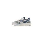 New Balance Baskets pour homme blanches et bleu marine, avec empiècements en mesh et synthétiques et détails en cuir.