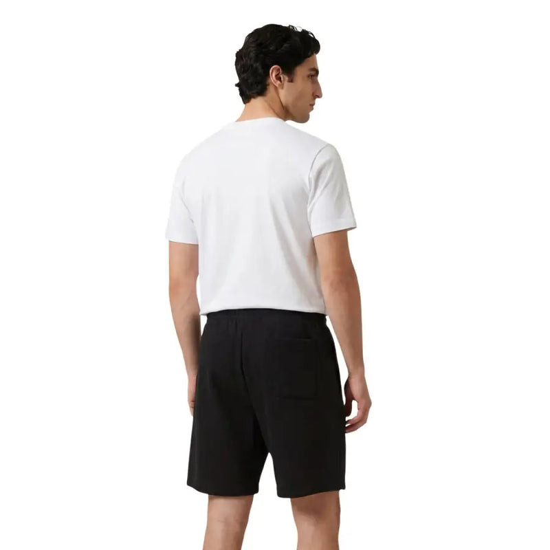Noir new balance hommes t-shirt avec un design minimaliste élégant et des poches latérales discrètes pour une tenue décontractée