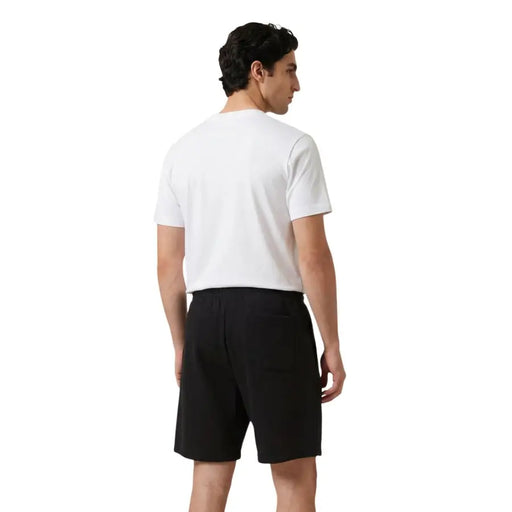 Noir new balance hommes t-shirt avec un design minimaliste élégant et des poches latérales discrètes pour une tenue décontractée