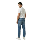 New balance hommes t-shirt associé à un jean en denim bleu présentant une coupe classique à cinq poches et un délavage subtil.