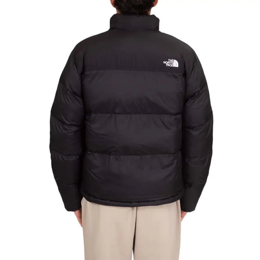 Black puffer jacket with the north face logo on the back.