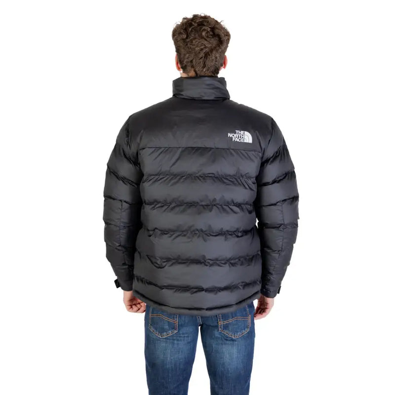 Black puffer jacket with white logo, denim jeans.
