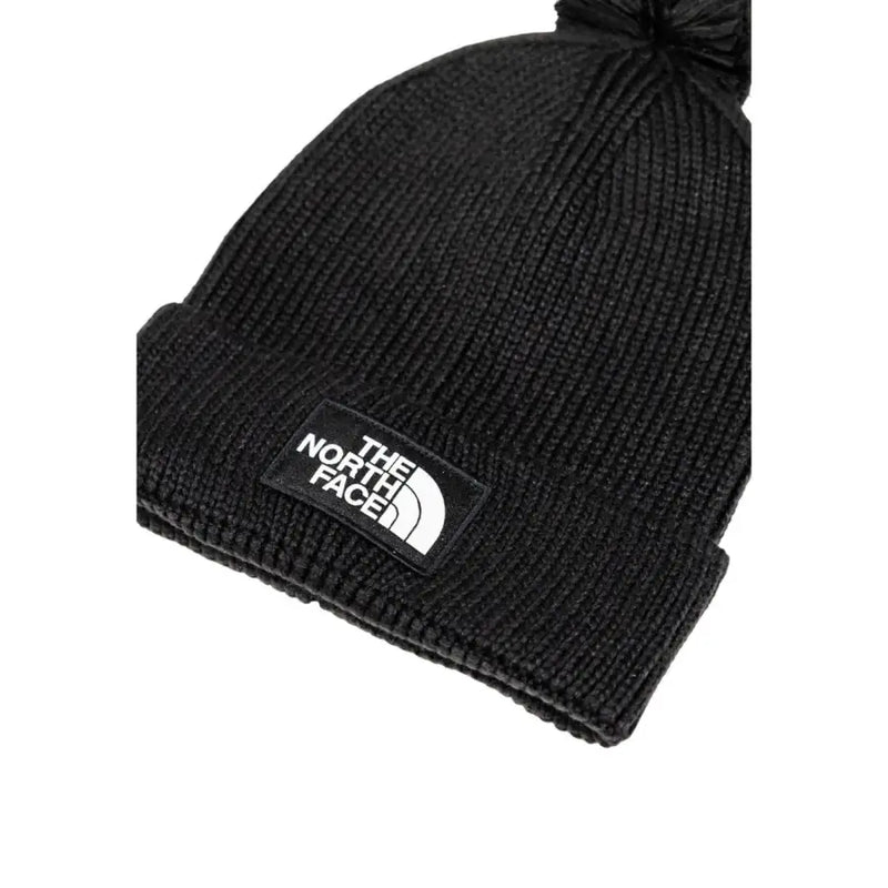 Black beanie with pom-pom and the north face logo.