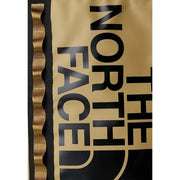 Sac à dos The North Face pour homme, beige imprimé, avec inscriptions noires dorées et bordures ondulées dorées sur les côtés.