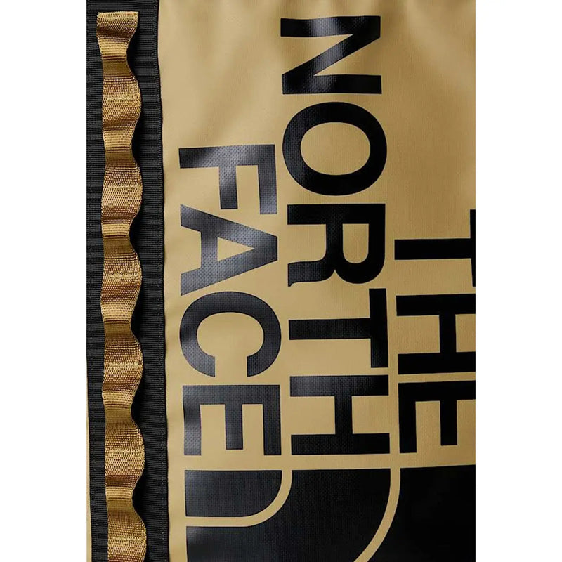 Sac à dos The North Face pour homme, beige imprimé, avec inscriptions noires dorées et bordures ondulées dorées sur les côtés.