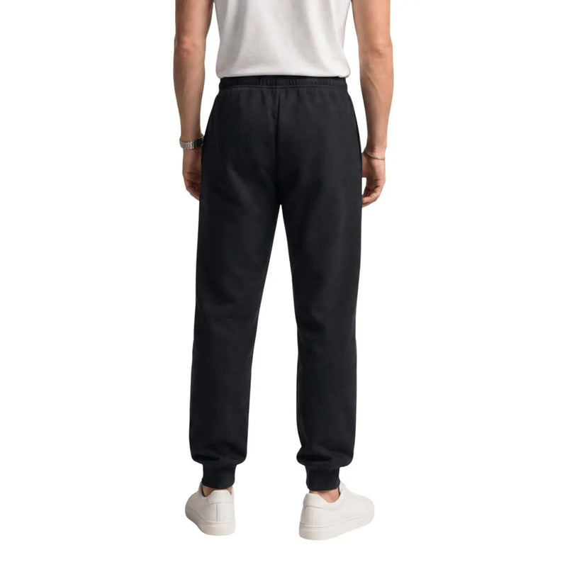 Pantalon de jogging The North Face pour homme, en molleton de coton noir, avec taille élastiquée et bas de jambes côtelés (vue de dos).