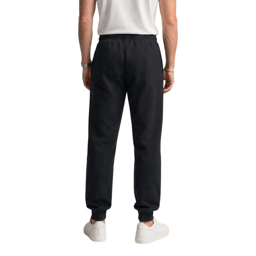 Pantalon de jogging The North Face pour homme, en molleton de coton noir, avec taille élastiquée et bas de jambes côtelés (vue de dos).