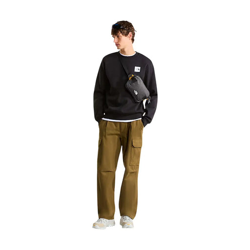 Sac bandoulière noir The North Face avec tirette de fermeture éclair jaune et logo blanc, porté avec un sweat-shirt noir en coton pour homme
