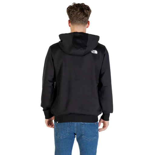Men’s black hooded sweatshirt with front pockets paired with blue jeans