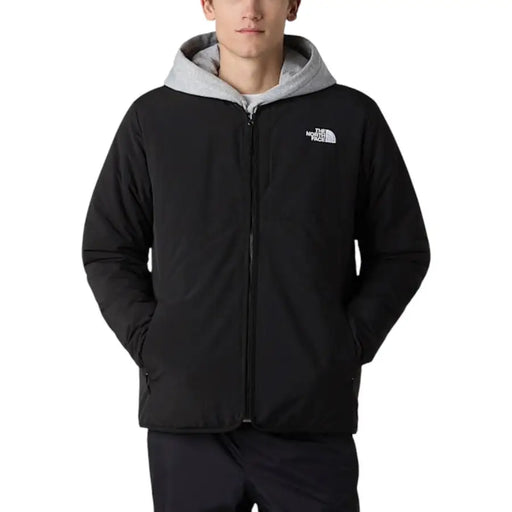 Le blazer pour homme The North Face, une veste longue en nylon noir zippée, est doté d'une capuche noire avec un intérieur doublé de gris et d'un logo sur la poitrine.