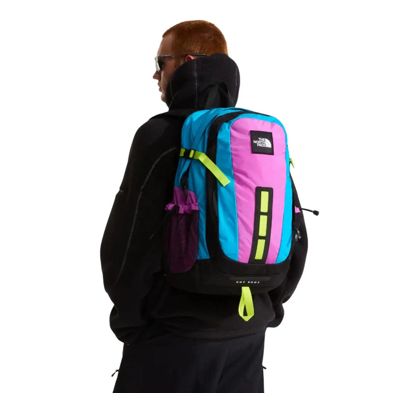 Sac à dos The North Face Hot Shot SE pour homme, en nylon violet, aux couleurs vives cyan et rose, avec des accents jaune fluo.
