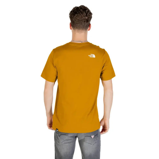Vue arrière d'un t-shirt à manches courtes The North Face pour homme, couleur jaune moutarde, avec logo blanc, en mélange de coton camel.