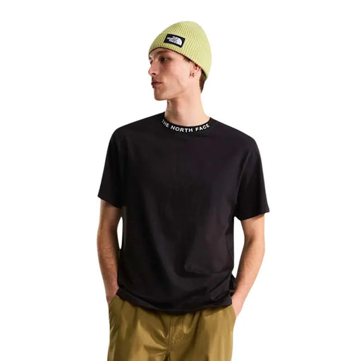 T-shirt noir à manches courtes The North Face pour homme t-shirt avec un logo autour du col porté par un mannequin