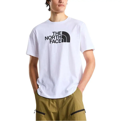 Blanc The North Face homme t-shirt avec un logo et un texte noirs sur le devant, idéal pour les tenues décontractées