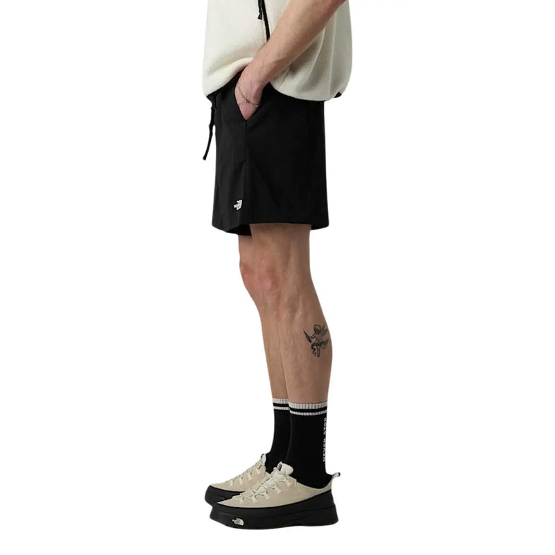 Short The North Face pour homme, noir, taille élastiquée avec cordon de serrage et logo blanc sur la jambe gauche (vue de face)
