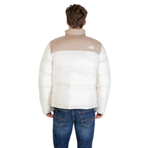 White and beige puffer jacket with the north face logo on the back.