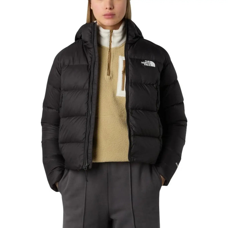 Doudoune The North Face pour femme en nylon noir, matelassée et ornée d'un logo blanc sur le devant de la poitrine.