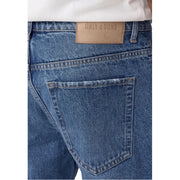 Back side of only and sons men light blue cotton jeans featuring a tan leather brand patch on the waistband