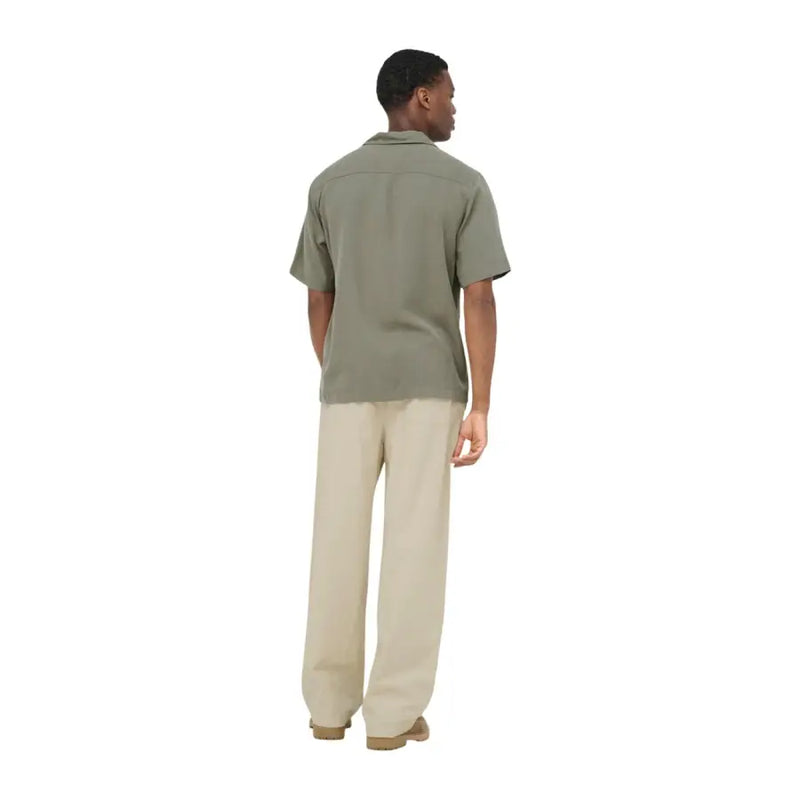 Un homme porte une chemise boutonnée vert olive à manches courtes, col classique et coupe décontractée. Only Fils
