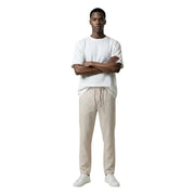 Un homme portant only & sons pantalon beige à cordon et un blanc t-shirt présentation de pantalons décontractés pour hommes
