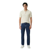 Un homme portant un Only polo blanc à manches courtes en coton côtelé crème pour homme, avec un jean bleu foncé.