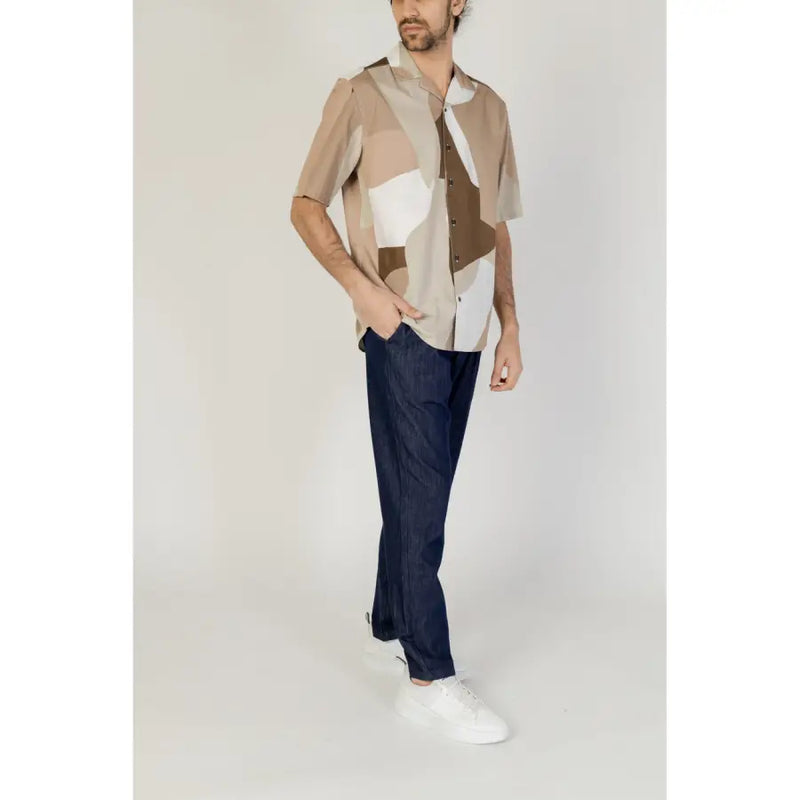 A man wearing an Only & Sons men’s short sleeve shirt with a beige white and brown geometric print pattern