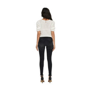 Vue de dos d'une dentelle blanche top avec des manches courtes à volants et une fermeture éclair au dos, associées à only jeans noirs en coton mélangé pour femmes