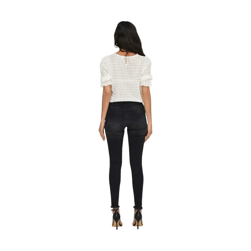 Vue de dos d'une dentelle blanche top avec des manches courtes à volants et une fermeture éclair au dos, associées à only jeans noirs en coton mélangé pour femmes