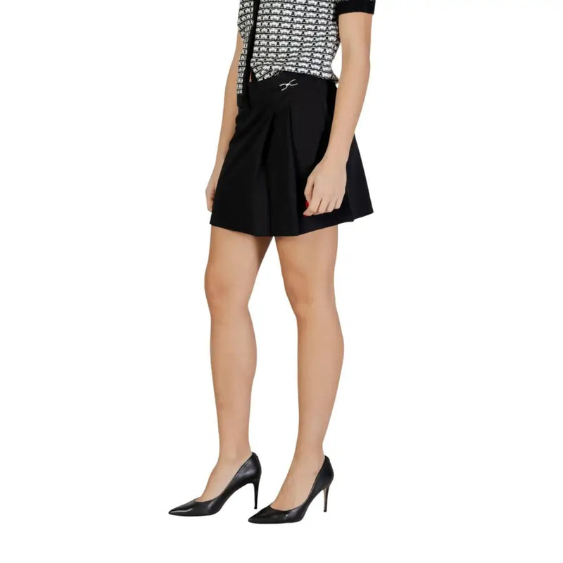Black pleated polyester mini skirt with zip featuring a subtle silver metallic bow at the waist for women only