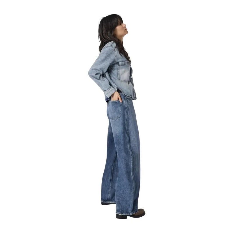 Une femme portant only Jean bleu clair pour femme, en coton denim, avec une veste en jean délavée et des manches retroussées.