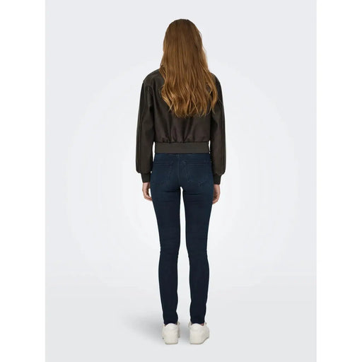 Only Blazer marron en polyester pour femme, avec de longues poches zippées, porté sur un blouson aviateur en cuir marron foncé et un jean skinny bleu.