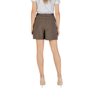 Woman wearing an olive green high-waisted skort with front pleat and belt