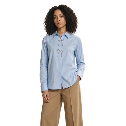 Only Polo long en coton bleu clair pour femme, orné de perles et d'un nœud blanc décoratif sur le devant.