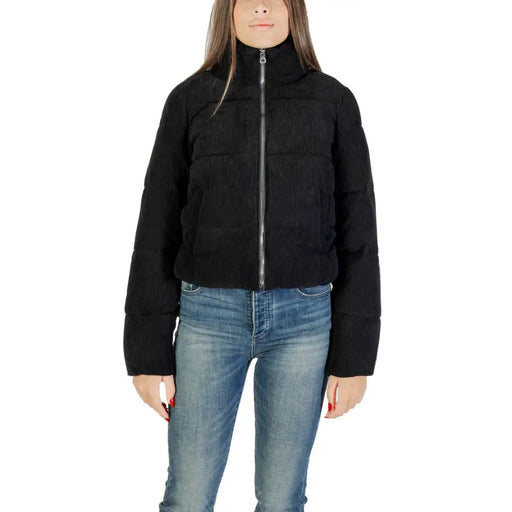 Women’s black puffer jacket with high collar and zip closure paired with blue jeans
