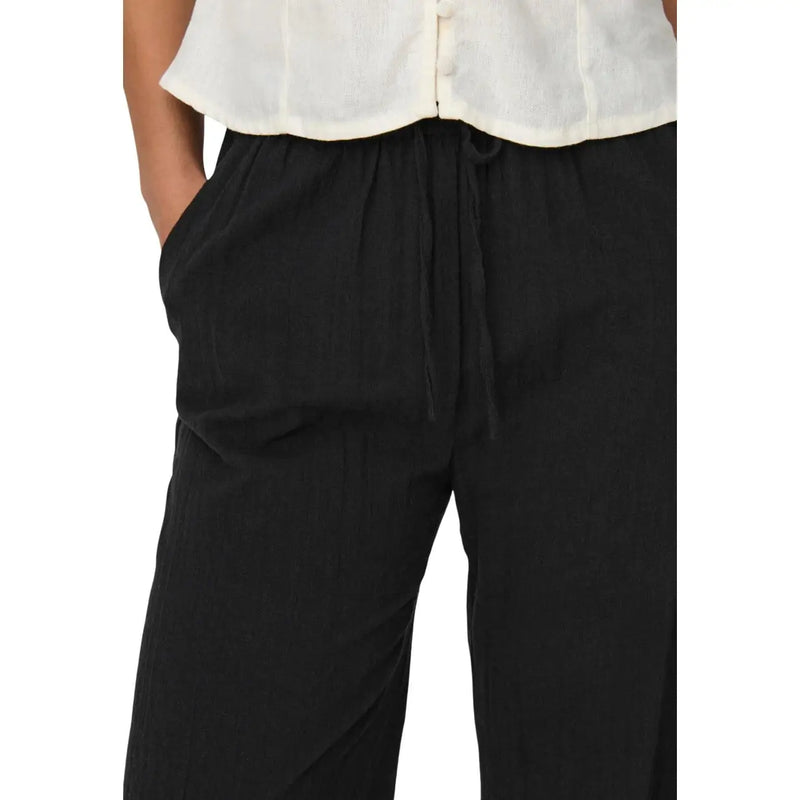 Only Pantalon noir en coton pour femme, orné de dentelle, coupe décontractée et plis verticaux discrets.