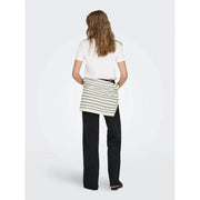 A white round neck cotton short t shirt paired with a white and black striped ribbed knit wrap skirt over dark trousers