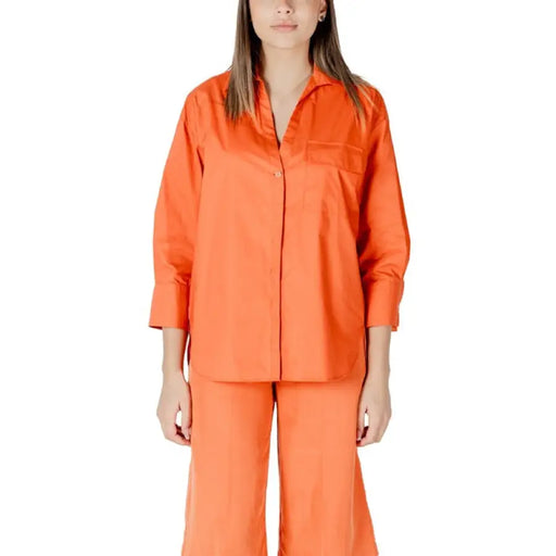 Orange shirt and pants set displayed on a retail mannequin for the Orange Shirt and Pants Set product