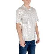 Un t-shirt blanc à manches courtes orné d'un motif géométrique gris répétitif, porté par un mannequin