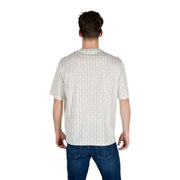 Un homme portant un t-shirt blanc à manches courtes à motifs géométriques gris clair discrets.