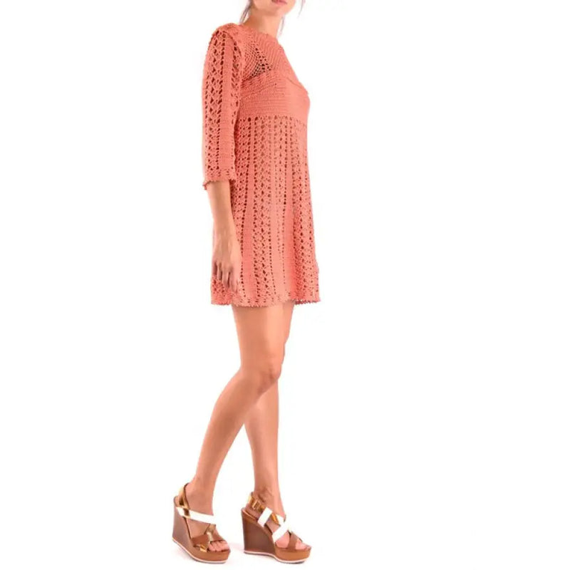 Peach crochet mini dress displayed in a stylish fashion setting