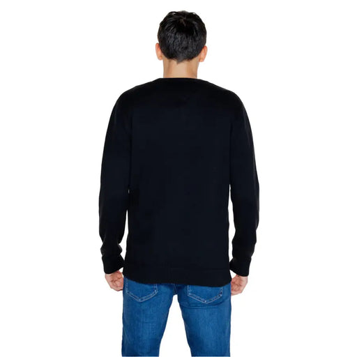 Person wearing a Black Long Sleeved Crewneck Sweater and Blue Jeans