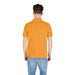 Person wearing a mustard colored short sleeve polo shirt and blue jeans